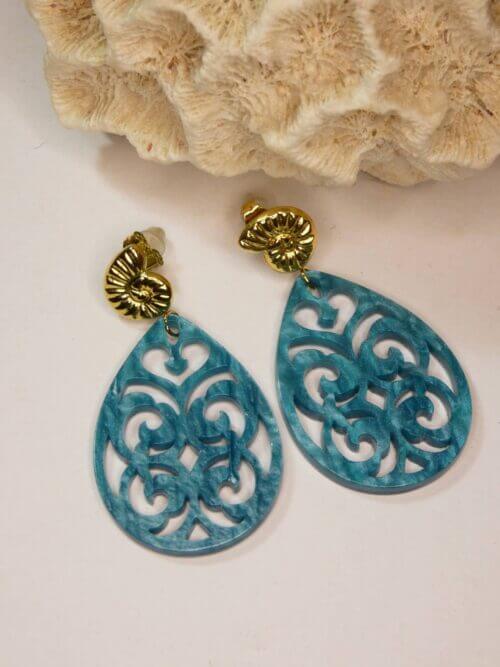 Boucles d'oreilles avec attache en acier en forme de coquillage et pendants arabesques en résine bleue. Bijou Sophia Célesta