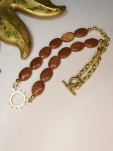 Collier couleur ambre et doré en acier inoxydable et perles goldstone. Bijou unique Sophia Célesta