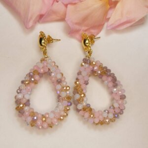 Clous d'oreilles dorés en forme de feuille stylisée et pendants gouttes en perles facettées dans des tons pastel de rose, mauve, blanc et doré. Bijou en exemplaire unique Sophia Célesta