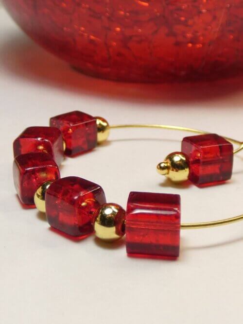 Boucles d'oreilles créoles originales avec ses cubes en verre rouge et ses perles en acier doré. Bijou en exemplaire unique Sophia Célesta