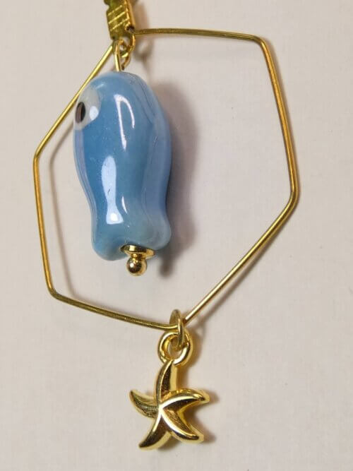 Boucles d'oreilles hexagonales dorées avec petit poisson en céramique bleue et étoile de mer dorée. Bijou en exemplaire unique Sophia Célesta