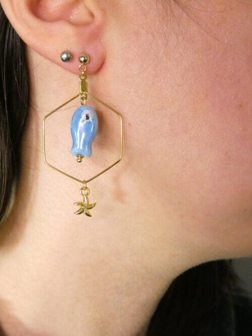 Boucles d'oreilles hexagonales dorées avec petit poisson en céramique bleue et étoile de mer dorée. Bijou en exemplaire unique Sophia Célesta