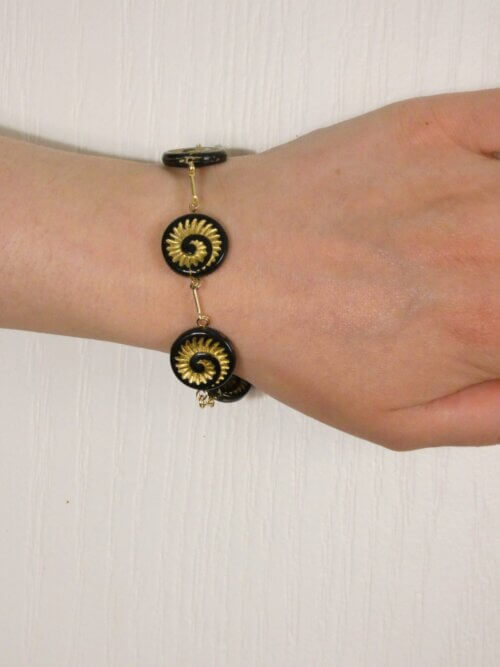 Bracelet doré avec perles plates en verre noir et motif nautile doré. Bijou en exemplaire unique Sophia Célesta