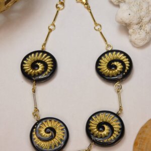Bracelet doré avec perles plates en verre noir et motif nautile doré. Bijou en exemplaire unique Sophia Célesta