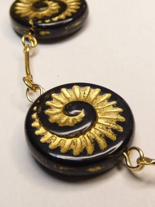 Bracelet doré avec perles plates en verre noir et motif nautile doré. Bijou en exemplaire unique Sophia Célesta